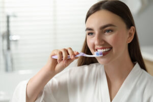 Student brushing teeth with fluoride toothpaste to strengthen enamel