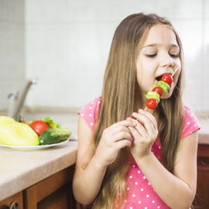Student eating crunchy vegetables for healthy teeth
